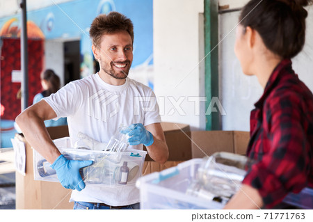 Man holding plastic containers with wastes 71771763