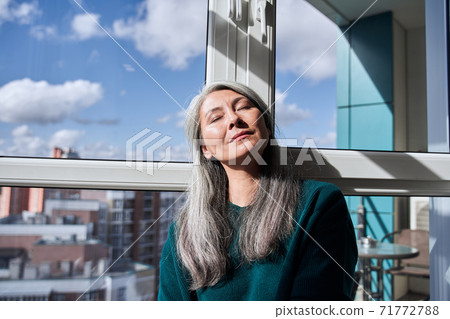 Woman sitting near the window Woman sitting near the window 71772788