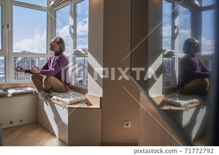 Man meditating at home Man meditating at home 71772792