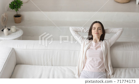 Happy millennial woman resting in living room with modern interior 71774173