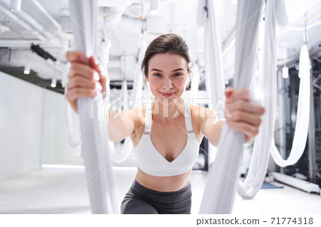 Woman in sportswear practicing fly or aerial yoga Woman in sportswear practicing fly or aerial yoga 71774318