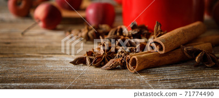 anise stars and cinnamon sticks with apples on a wooden table. anise stars and cinnamon sticks with apples on a wooden table. 71774490