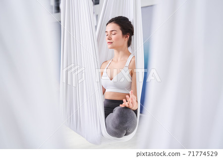 Woman practicing yoga and doing Ardha Padmasana Woman practicing yoga and doing Ardha Padmasana 71774529