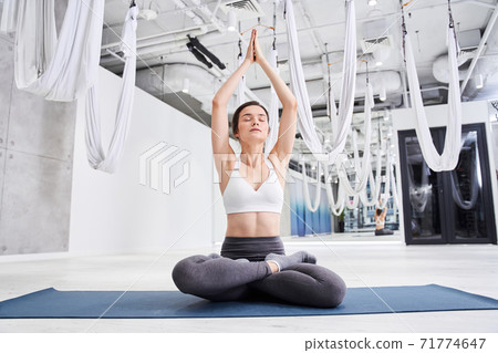 Woman with hands in namaste under her head Woman with hands in namaste under her head 71774647