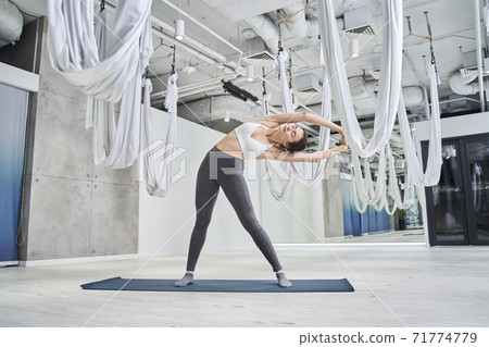 Woman doing pose of the Crescent browsing Indudalasana 71774779