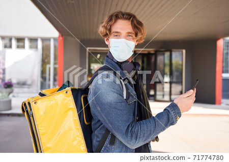 Man standing at the street with backpack with food 71774780