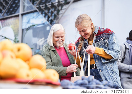 Woman looking into the shopper bag Woman looking into the shopper bag 71775984