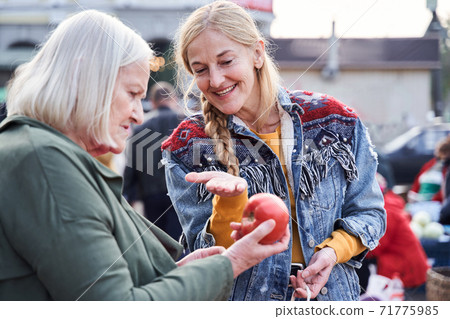 Woman pointing with hand to the red apple Woman pointing with hand to the red apple 71775985