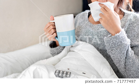 Sick asian woman have hight fever flu and take medicine on bed in bedroom, Medical and health concept, Selective focus. Sick asian woman have hight fever flu and take medicine on bed in bedroom, Medical and health concept, Selective focus. 71777497