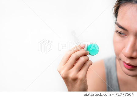 Asian woman holding contact lens and artificial tears on white background, Selective focus on contact lens , myopia and eyesight problem concept. Asian woman holding contact lens and artificial tears on white background, Selective focus on contact lens , myopia and eyesight problem concept. 71777504