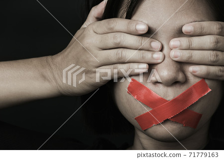 Asian woman blindfold wrapping mouth with red adhesive tape Asian woman blindfold wrapping mouth with red adhesive tape 71779163