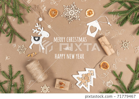 XMAS or New Year postcard. Frame, border made from boxes, twine, wood decoration, dried oranges and spruce branches on craft beige background. Concept Zero waste Merry Christmas Copy space XMAS or New Year postcard. Frame, border made from boxes, twine, wood decoration, dried oranges and spruce branches on craft beige background. Concept Zero waste Merry Christmas Copy space 71779467