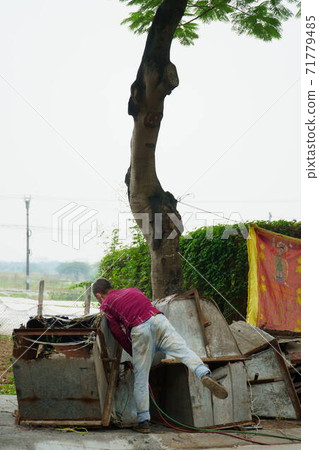 A Vietnamese man who runs a demolition business under a roadside tree A Vietnamese man who runs a demolition business under a roadside tree 71779485