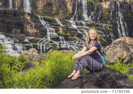 Young woman hiker, tourist on the background of Amazing Pongour Waterfall is famous and most beautiful of fall in Vietnam. Not far from Dalat city estimate 45 Km. Dalat, Vietnam Young woman hiker, tourist on the background of Amazing Pongour Waterfall is famous and most beautiful of fall in Vietnam. Not far from Dalat city estimate 45 Km. Dalat, Vietnam 71780586