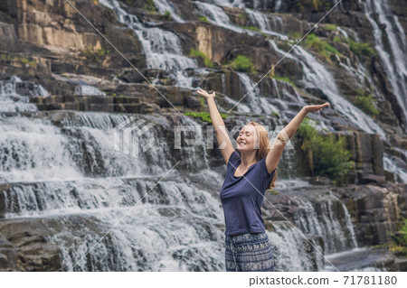 Young woman hiker, tourist on the background of Amazing Pongour Waterfall is famous and most beautiful of fall in Vietnam. Not far from Dalat city estimate 45 Km. Dalat, Vietnam Young woman hiker, tourist on the background of Amazing Pongour Waterfall is famous and most beautiful of fall in Vietnam. Not far from Dalat city estimate 45 Km. Dalat, Vietnam 71781180