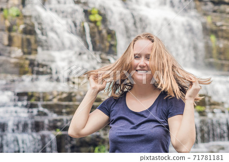 Young woman hiker, tourist on the background of Amazing Pongour Waterfall is famous and most beautiful of fall in Vietnam. Not far from Dalat city estimate 45 Km. Dalat, Vietnam 71781181