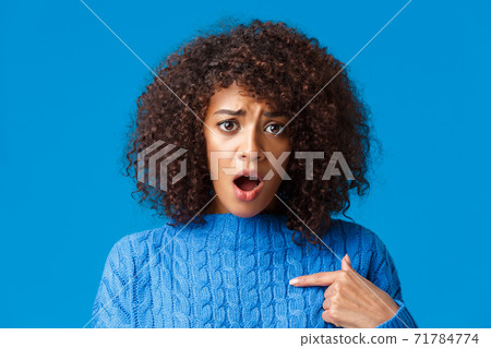 Close-up portrait offended and upset silly timid african-american woman was accused or blamed, pointing herself and looking insulted, gasping staring at something unfair, standing blue background 71784774