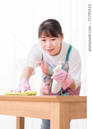 噴灑清潔劑並擦桌子的女人的手焦點 71785810