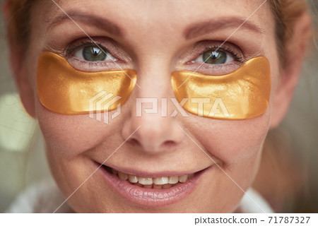 Portrait of middle aged woman with under eyes patches Portrait of middle aged woman with under eyes patches 71787327