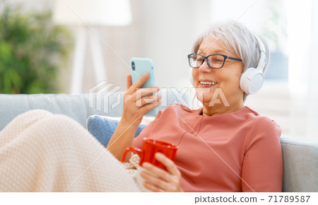 Senior woman listening to music 71789587