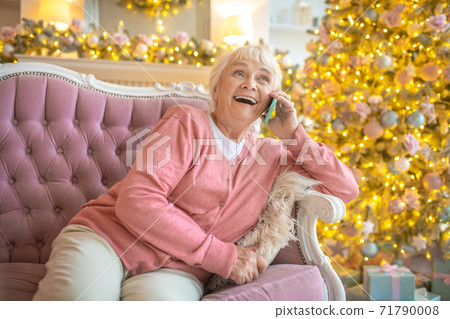 Woman sitting on a sofa and having a nice talk on the phone 71790008