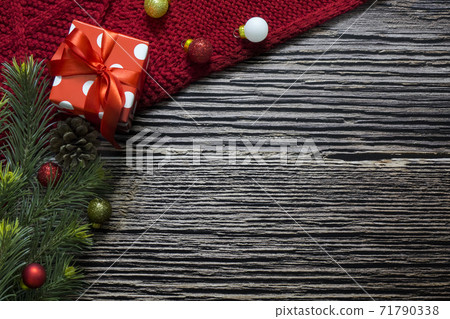 Christmas frame with red scarf, balls, gift box and fir branches on wood with copy space for text 71790338