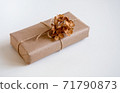 Gift box wrapped in craft paper with natural rustic rope on a white background with dried hydrangea flowers 71790873
