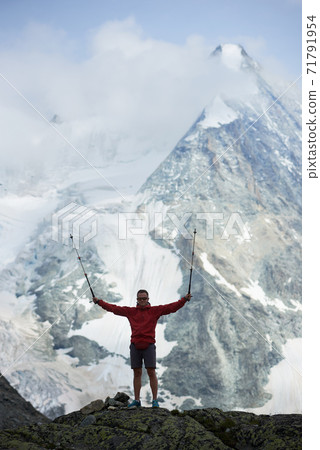 Tourist posing in mountains using trakking sticks. Tourist posing in mountains using trakking sticks. 71791954