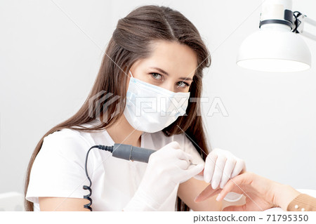 Manicure master making manicure. 71795350