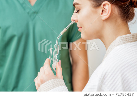 Woman receives nasal inhalation. 71795437