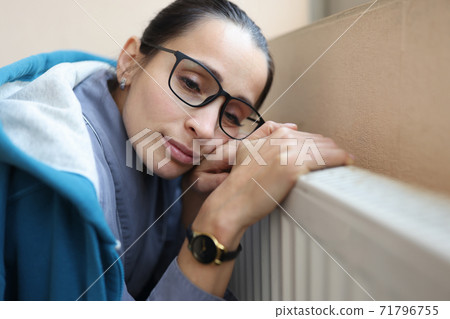 Sad woman holds her hands on battery. 71796755