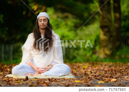 Girl practices yoga among the autumn leaves Girl practices yoga among the autumn leaves 71797985