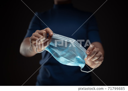Close up shot of hands holding protective face mask. Close up shot of hands holding protective face mask. 71799885