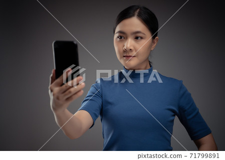 Asian woman scans face by smart phone using facial recognition system. Asian woman scans face by smart phone using facial recognition system. 71799891