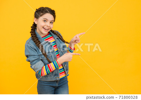 Excited little girl with braids wear denim clothes, promoting goods concept Excited little girl with braids wear denim clothes, promoting goods concept 71800328