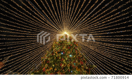 Beautiful illumination in the form of a tent over the New Year tree in the city. Beautiful illumination in the form of a tent over the New Year tree in the city. 71800914