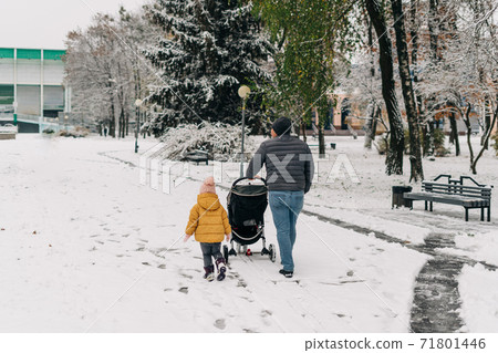 Father with child and baby walking with stroller in winter snow park. Happy family, connections on 71801446