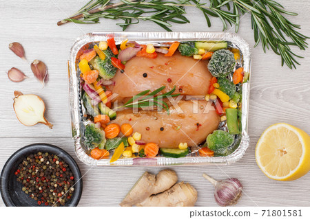 Raw chicken breasts or fillet in metal container with ingredients. Raw chicken breasts or fillet in metal container with ingredients. 71801581