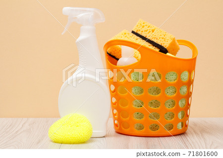Bottles of dishwashing liquid, basket and sponges on beige background. Bottles of dishwashing liquid, basket and sponges on beige background. 71801600