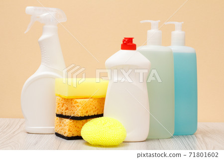 Bottles of dishwashing liquid and sponges on beige background. Bottles of dishwashing liquid and sponges on beige background. 71801602
