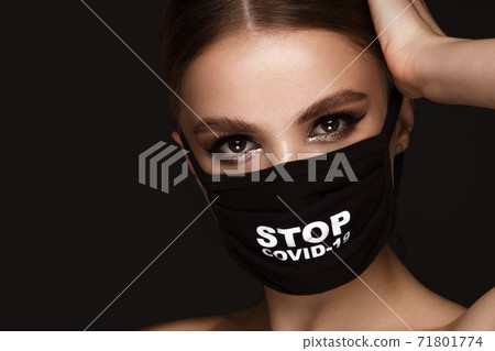 Portrait of a beautiful woman in a black mask stop covid and classic makeup. Mask mode during the covid pandemic 71801774