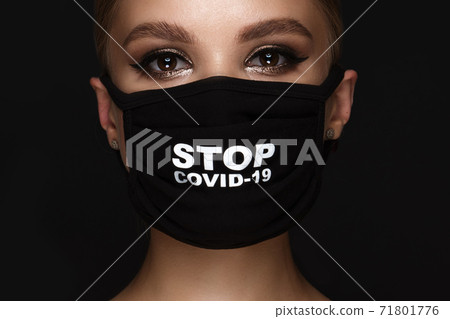 Portrait of a beautiful woman in a black mask stop covid and classic makeup. Mask mode during the covid pandemic 71801776