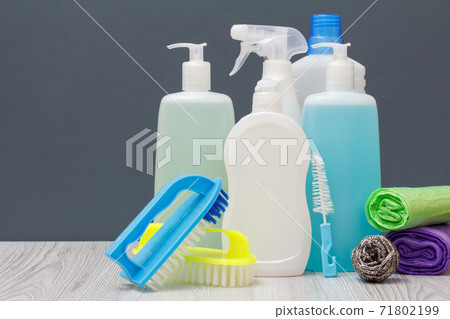 Bottles of dishwashing liquid, brushes and garbage bags on gray background. Bottles of dishwashing liquid, brushes and garbage bags on gray background. 71802199