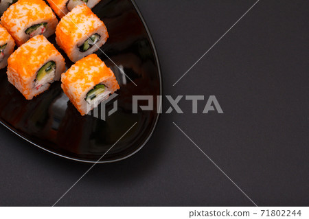 Uramaki California. Sushi rolls on a plate with black background. Uramaki California. Sushi rolls on a plate with black background. 71802244