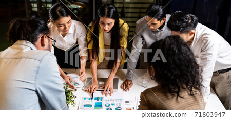 Working late, interracial asian business team brainstorm idea meeting Panorama. Working late, interracial asian business team brainstorm idea meeting Panorama. 71803947