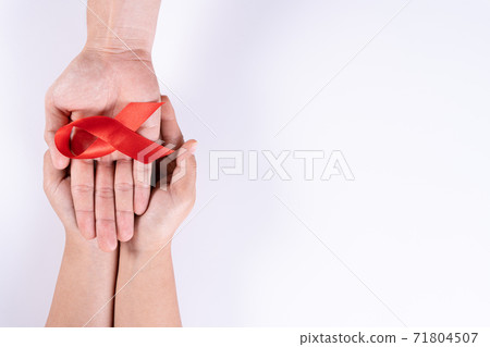 Aids awareness, man and woman hands holding red ribbon on white background with copy space for text. World Aids Day, Healthcare and medical concept. 71804507