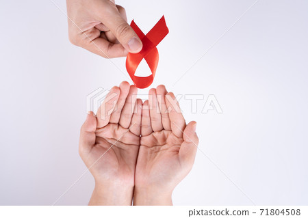 Aids awareness, man and woman hands holding red ribbon on white background with copy space for text. World Aids Day, Healthcare and medical concept. 71804508