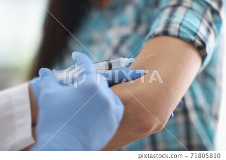 Doctor injects the patient in the shoulder 71805810