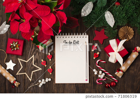 Empty notebook to do list, red flower poinsettia, Christmas decorations, gift boxes on dark wooden background. Empty notebook to do list, red flower poinsettia, Christmas decorations, gift boxes on dark wooden background. 71806319