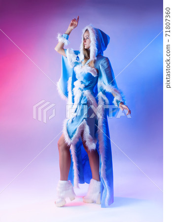 a woman in a blue snow maiden costume poses on a light neon background a woman in a blue snow maiden costume poses on a light neon background 71807360